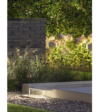 in-lite Evo Hyde 180 12v light illuminating garden and waterfall.